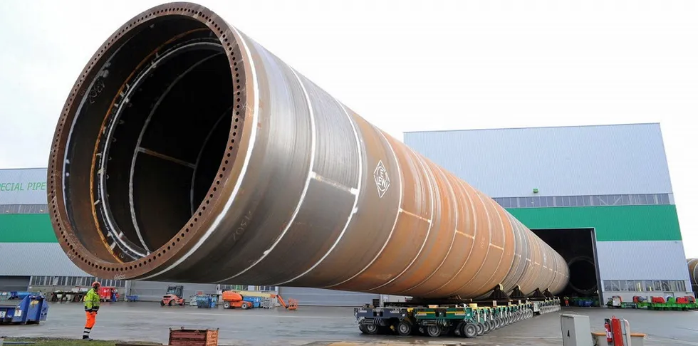 Giant XXL monopile being moved out of EEW production hall in Rostock, Germany