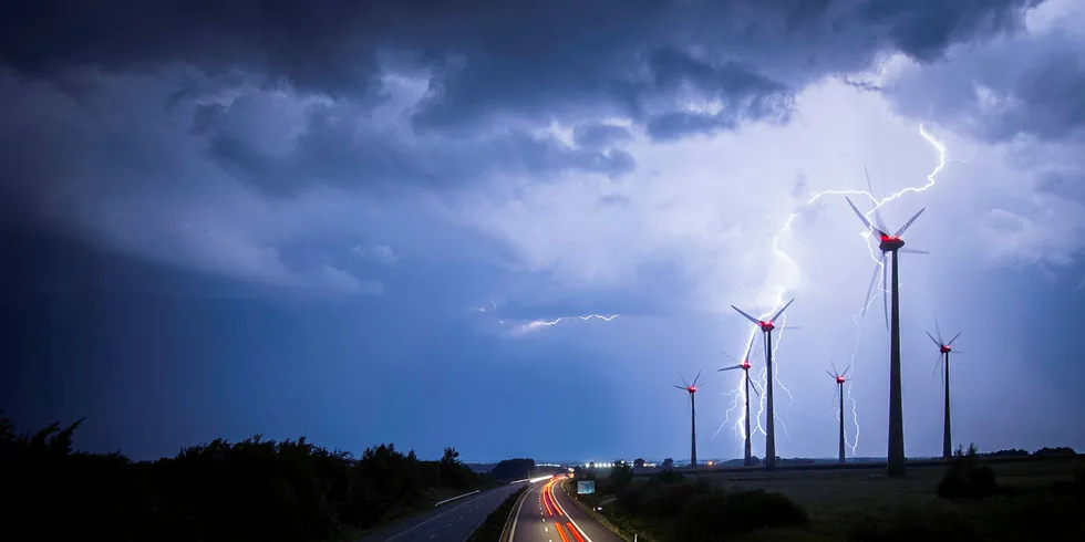 Lightning strikes behind a wind farm in Goerlitz, Germany, close to the Polish border