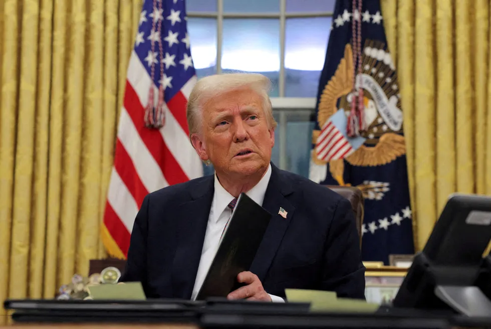 US President Donald Trump signs documents as he issues executive orders in the Oval Office at the White House on Inauguration Day in Washington DC on 20 January.