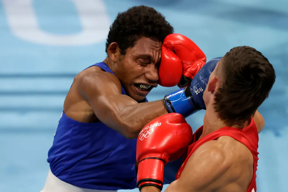Taking a hit: Harry Garside of Australia in action against John Ume of PNG at the Tokyo Olympics