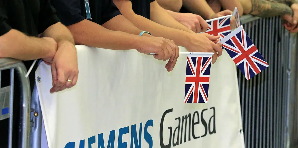 Employees hold national flags as Britain's Queen Elizabeth II visits the Siemens Gamesa Renewable Energy wind turbine blade factory in Kingston upon Hull, in northern England.