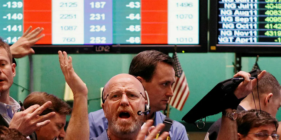 Traders gesture at each other while working in the crude oil and natural gas options pit on the floor of the New York Mercantile Exchange March 7, 2011.