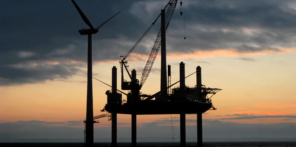 Offshore wind turbine and installation jackup in silouette in the North Sea