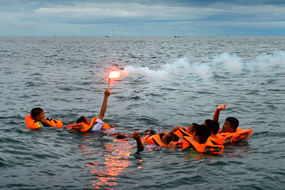 Attention: Drill participants wave a smoke flare for search and rescue teams.