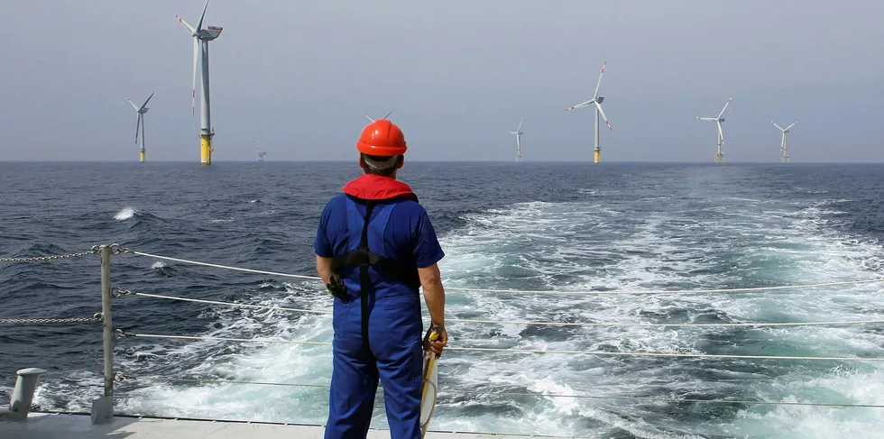 A worker looks out at wind turbines at the Alpha Ventus offshore wind farm of the German coast