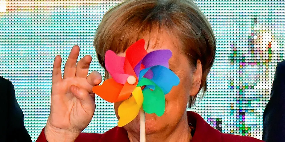German Chancellor Angela Merkel is partly hidden by a toy wind wheel as she poses with children during the opening ceremony of the Arkona wind park in Sassnitz, northern Germany.