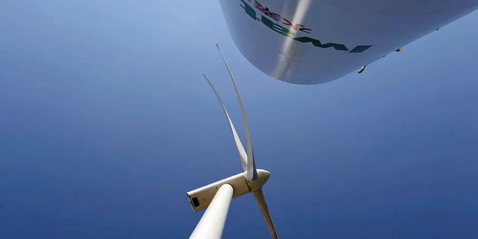 A wind turbine next ti a hydrogen tank.