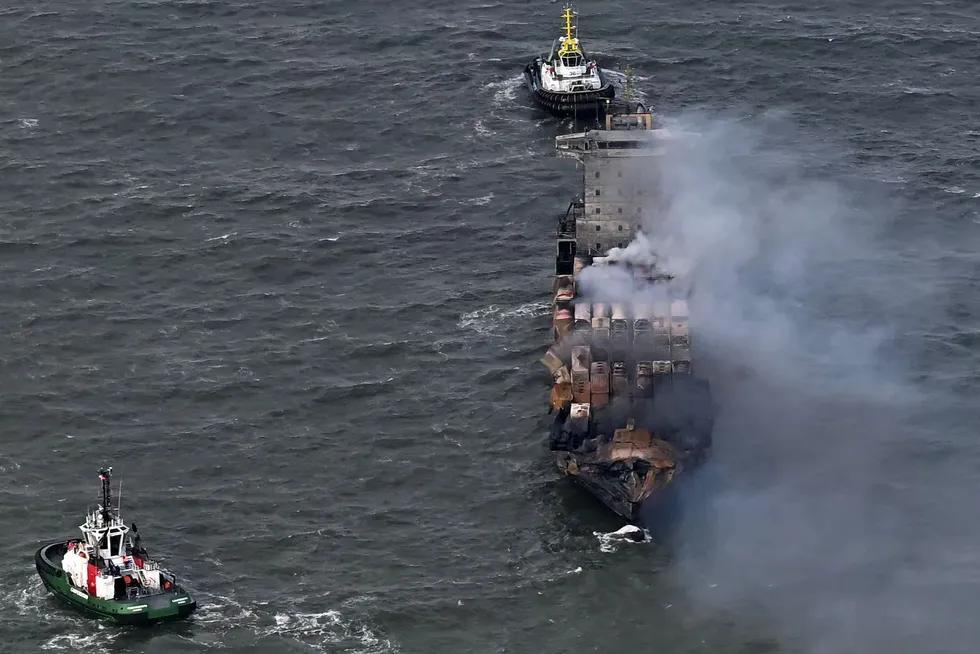 Smoke rises from the deck of the Solong as tugs stand off in the North Sea on Tuesday following Monday's collision.