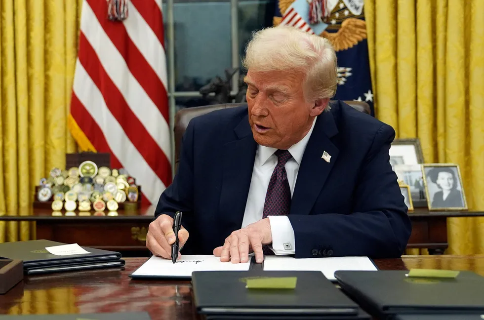 President Donald Trump signs an executive order in the Oval Office of the White House, on Monday.