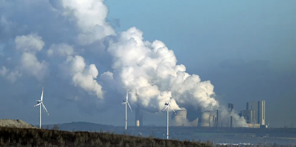 Wind turbines in front of a coal-fired power plant in Neurath, western Germany.
