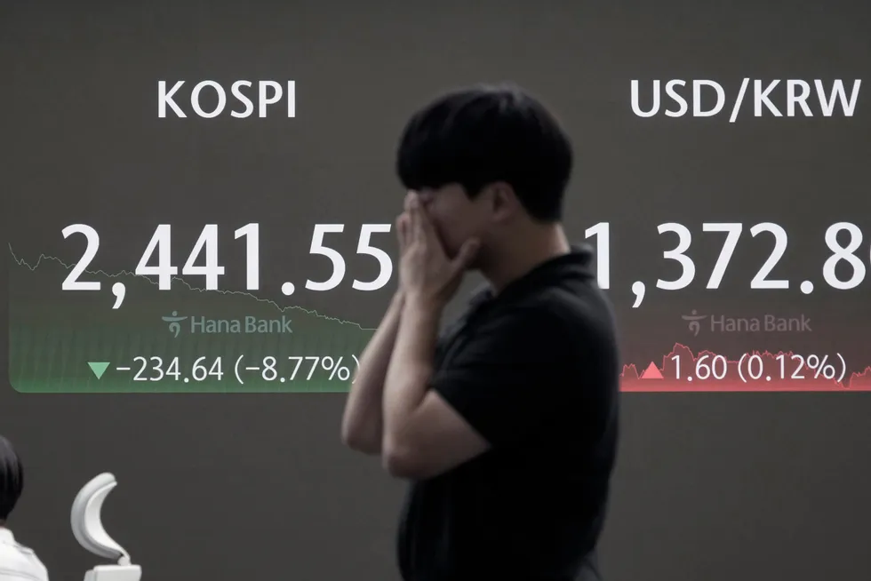 A trader reacts near a screen showing the Korea Composite Stock Price Index (KOSPI), in this file photo.