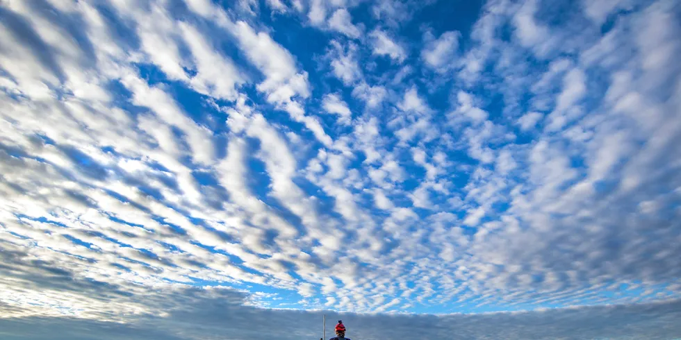 Turbine technician atop a GE turbine on a wind farm in the US