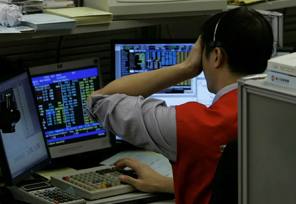 A floor trader reacts as he watches the stock prices at Hong Kong Stock Exchange in Hong Kong