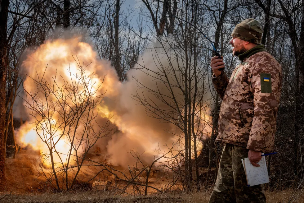 A Ukrainian officer stands near a firing howitzer in the Donetsk region of Ukraine in March 2024.