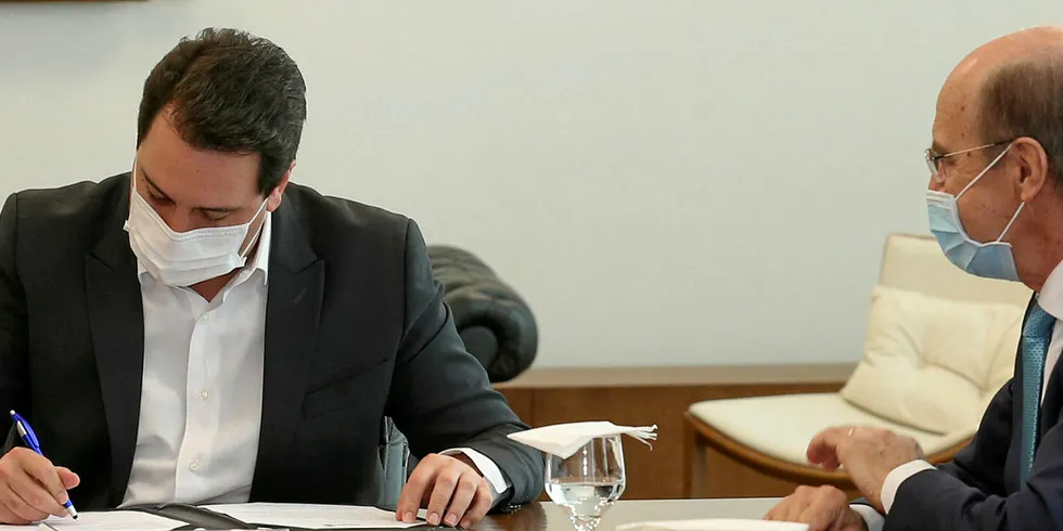 C.Vale CEO Alfredo Lang (right) watches as Parana state governor Carlos Massa Ratinho Junior puts pen to paper on the deal.
