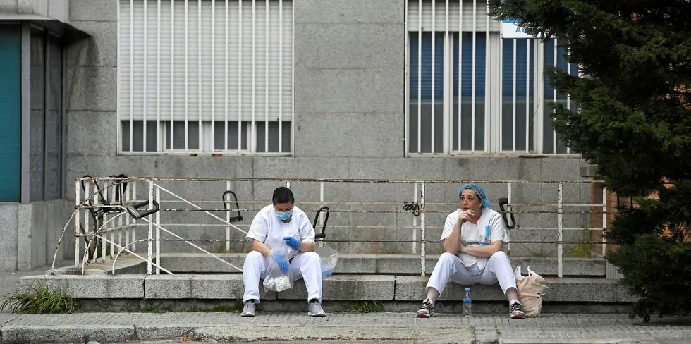 Exhausted health workers outside a hospital in Madrid