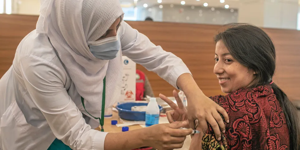 A health worker receives an Oxford-AstraZeneca vaccine dose in Dhaka, Bangladesh