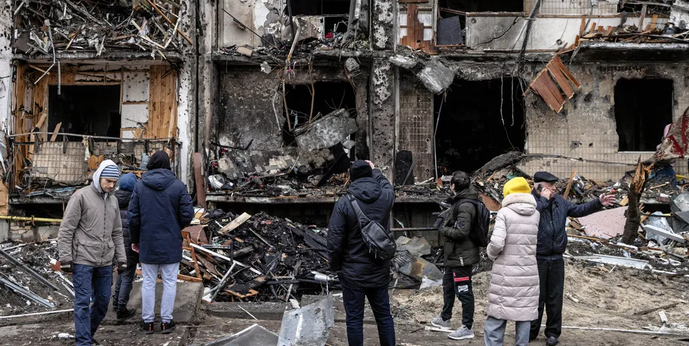 People look at the exterior of a damaged residential block hit by an early morning missile strike on February 25, 2022 in Kyiv, Ukraine