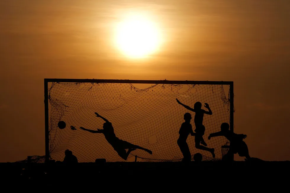 Scored: youths play soccer on a beach in Luanda, Angola where BP and Eni have the goal of boosting production by 25% in the next five years