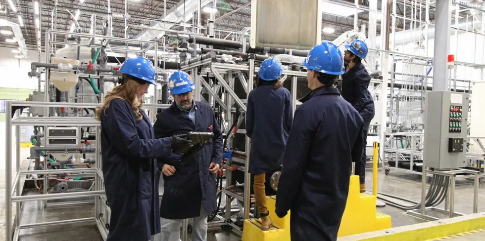 Electra staff inspect a plate of iron made at the pilot plant.