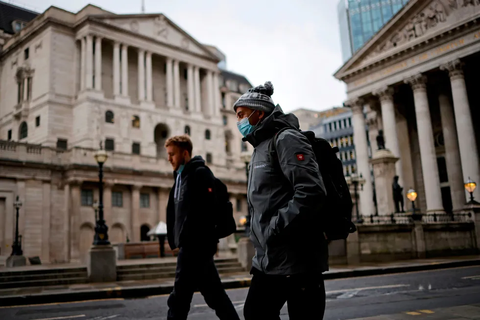Call for leadership: pedestrians wearing a face covering walk on front of the Bank of England, which has been urged to stop buying high-carbon bonds by UK parliamentarians