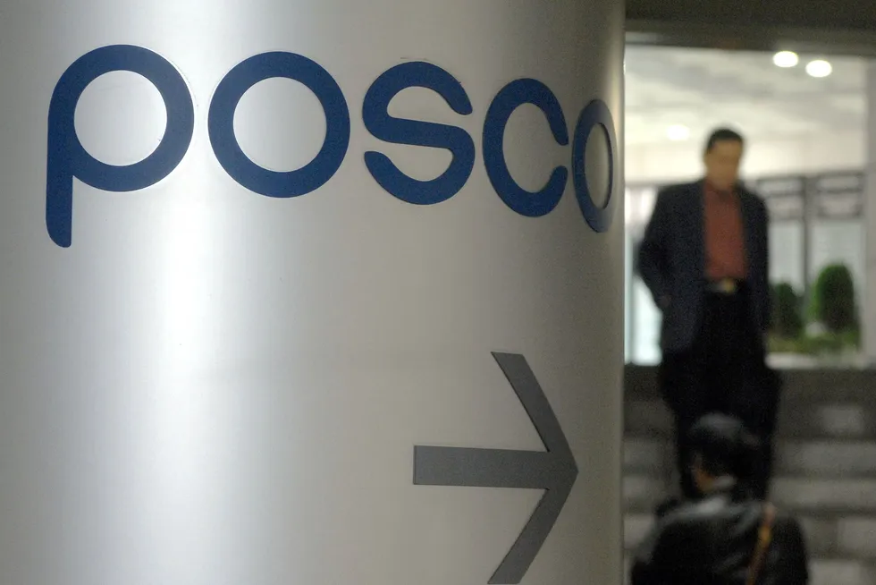 A file pic from 2007 shows pedestrians walking past a logo of Posco in front of the company's headquarters in Seoul, South Korea.