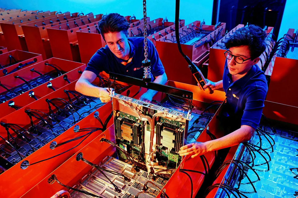 Bits and bytes: technicians inspecting computer equipment housed in Down Under GeoSolutions’ patented cooling tanks