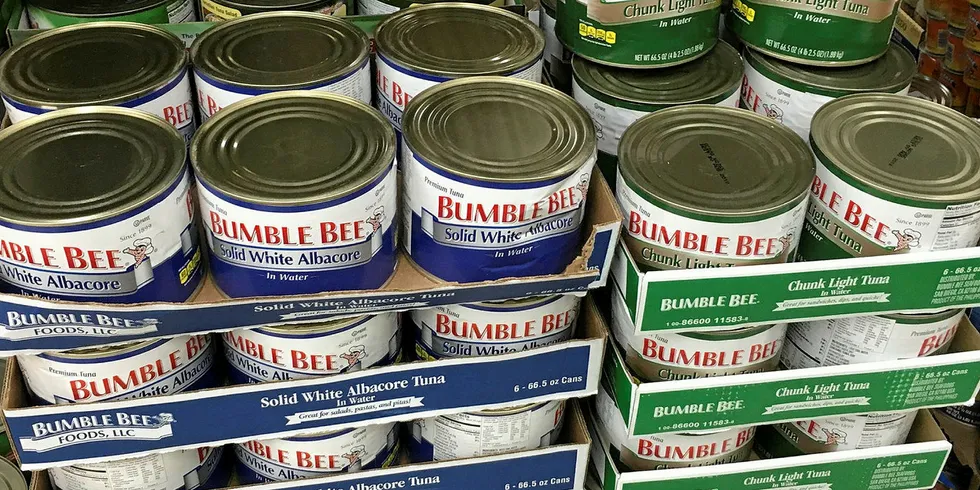 Bumble Bee tuna cans stacked high. The company and its former executives remain in trouble.