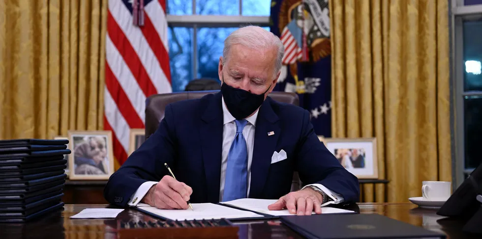 US President Joe Biden sits in the Oval Office as he signs a series of orders at the White House in Washington, DC, after being sworn in at the US Capitol on January 20, 2021.