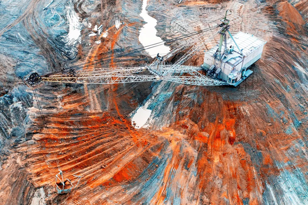 A large walking excavator works in a quarry for the extraction of rare metals.