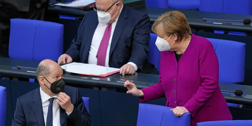 German finance minister Olaf Scholz (l), energy minister Peter Altmaier (background) and Chancellor Angela Merkel(r).