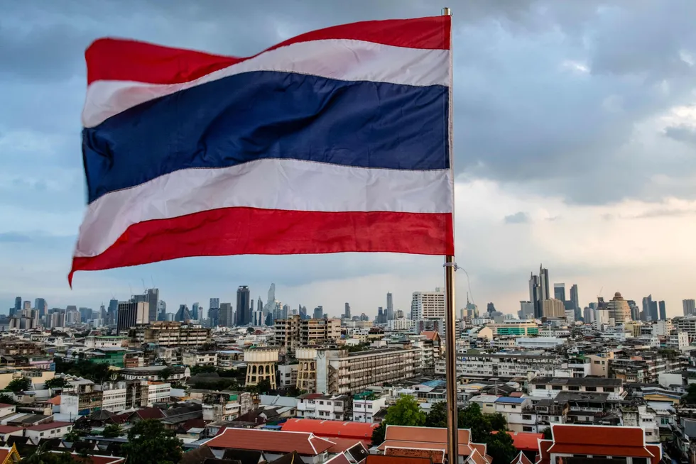 Thailand's national flag flies over the city skyline in Bangkok