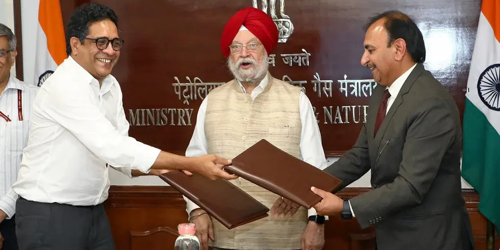 Greenko CEO Anil Kumar Chalamalasetty, left, and ONGC director Anurag Sharma exchange signed MoUs for the project as Indian petroleum minister Hardeep Singh Puri, centre, looks on.