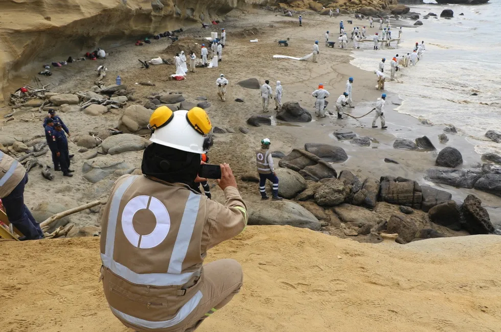 OEFA overseeing oil spill containment activities by Perupetro workers.