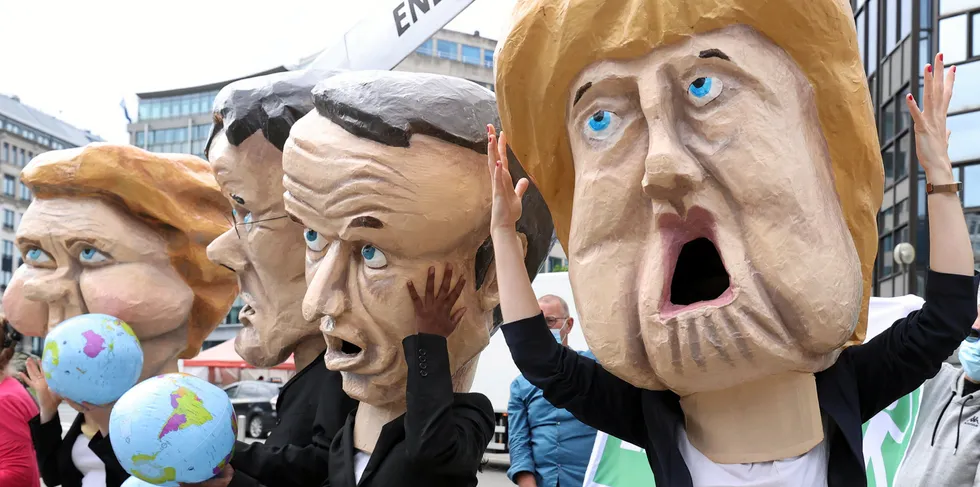 Climate activists stage a demonstration in front of the EU Council building to highlight the threat of the Energy Charter Treaty (ECT) to climate as they wear huge model heads of European Commission President Ursula von der Leyen, Dutch Prime Minister Mark Rutte, French President Emmanuel Macron and German Chancellor Angela Merkel in Brussels, Belgium.