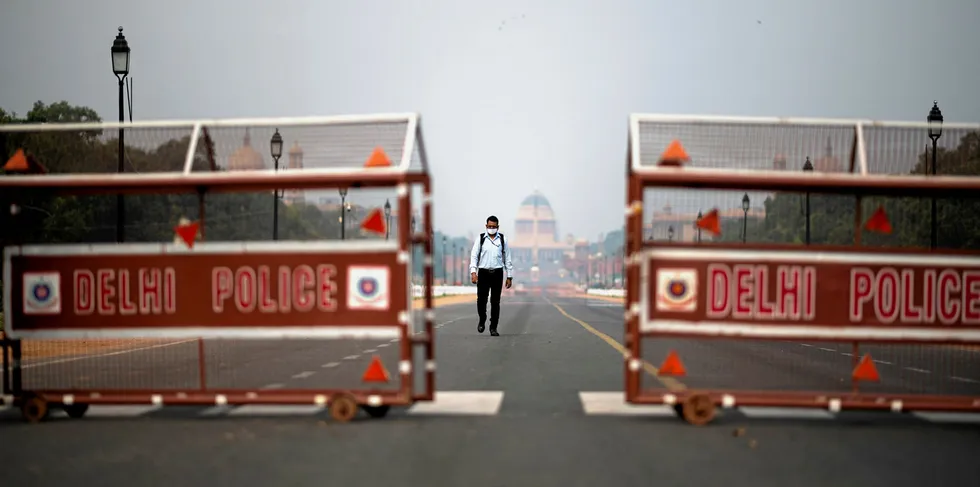 A man walks on a deserted Rajpath leading to the Presidential Palace during a government-imposed lockdown as a preventive measure against the COVID-19 coronavirus in New Delhi.