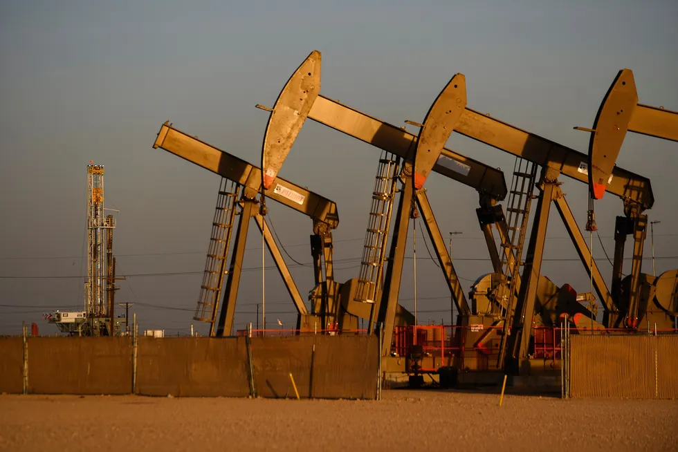 An array of pumpjacks operate near the site of a new oil and gas well being drilled Friday, 8 April 2022 in Midland, Texas.