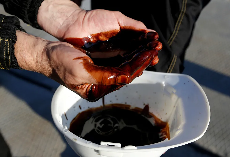 Wanted commodity: employees demonstrate a sample of oil from a well at the Rosneft-operated Priobskoye oilfield in Russia's Khanty-Mansiysk region