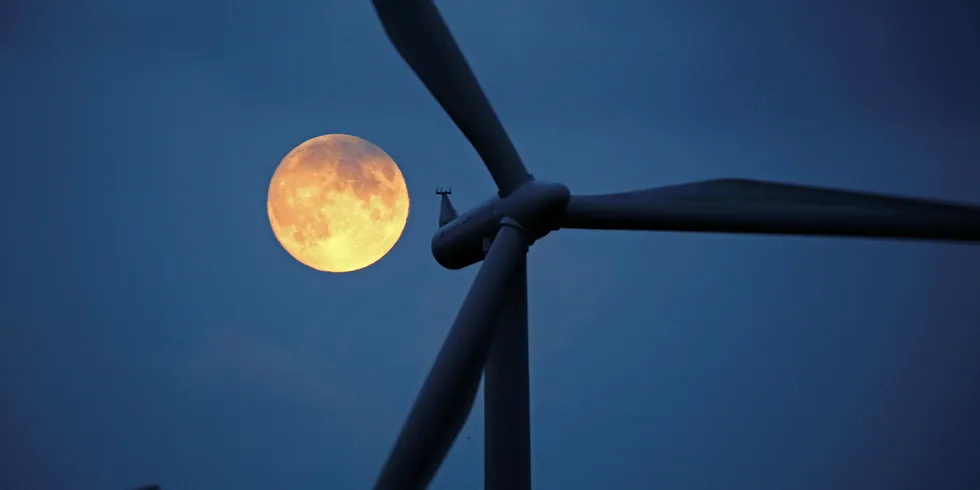 The moon rises behind the turbines of ScottishPower's Whitelee Windfarm.