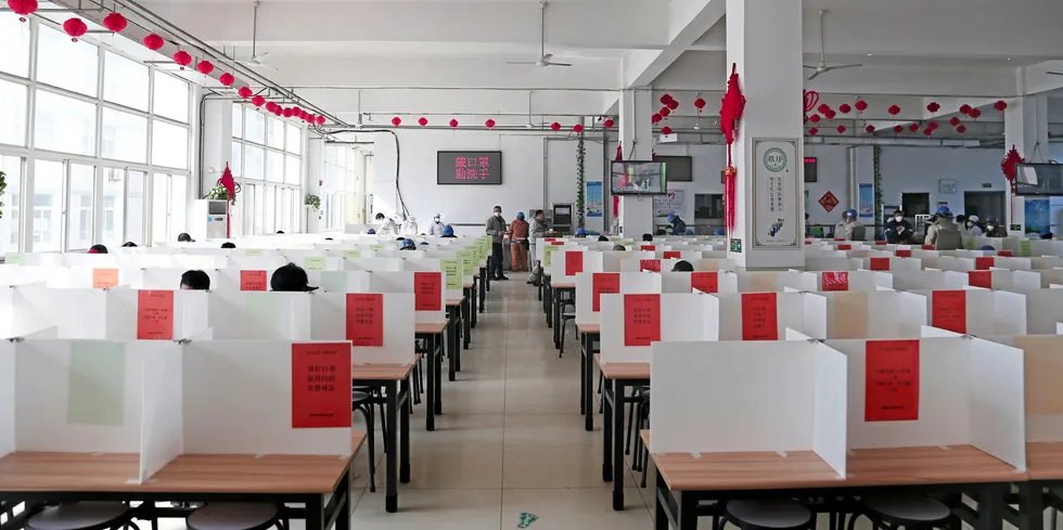 Partitioned dining tables at the CIMC Raffles canteen, which the Chinese yard introduced to help prevent workers from contracting coronavirus. Printed on the red paper signs is the precautionary advice: no chatting, no gathering, eat fast and leave soon.