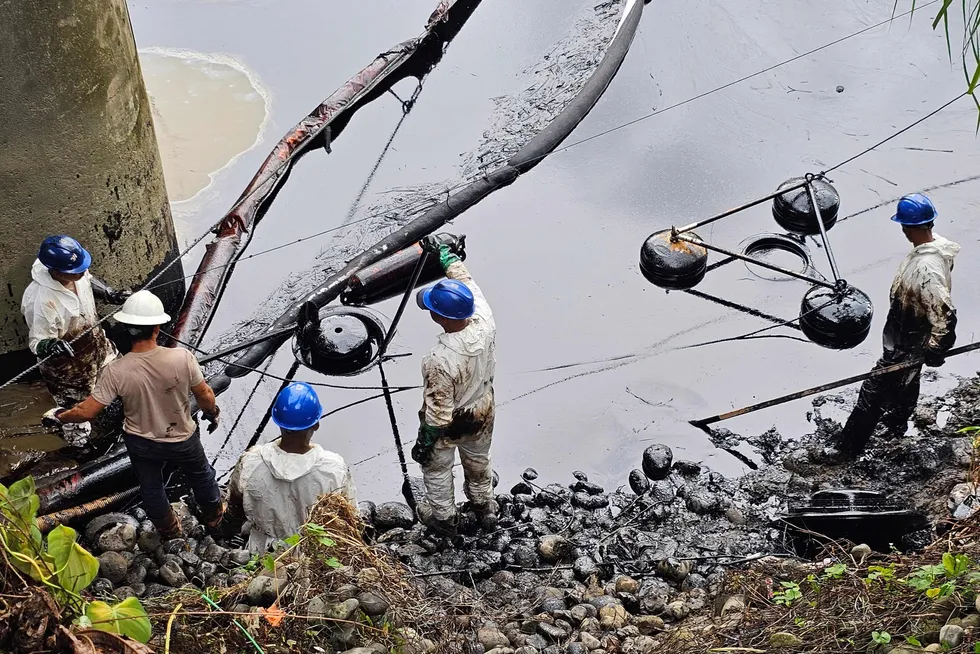 Employees of Petroecuador working to clean an oil spill at the Viche River caused by a damage at the SOTE pipeliine.