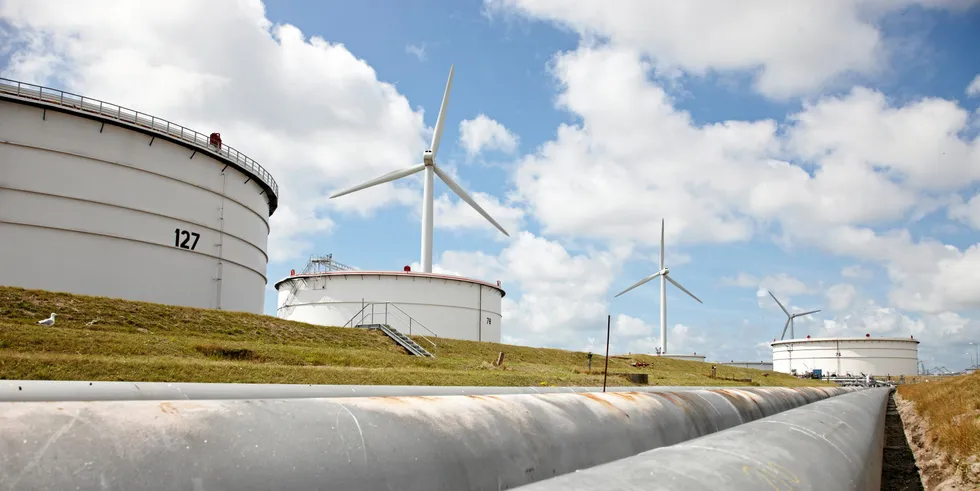 A view a the pipework running past storage tanks and wind turbines at BP's Rotterdam refinery in the Netherlands