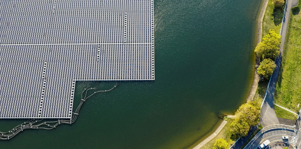 Vehicles pass along a road on the shoreline near Yamakura Dam floating solar plant in Ichihara, Japan