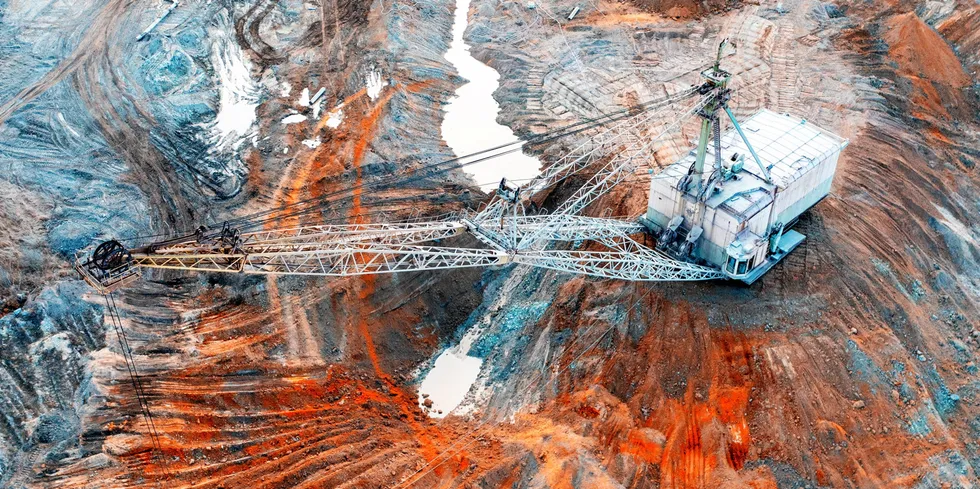 A large walking excavator works in a quarry for the extraction of rare metals.