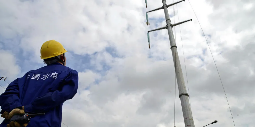 A Chinese engineer from PowerChina and Sinohydro watches the building site of a high-voltage power line.
