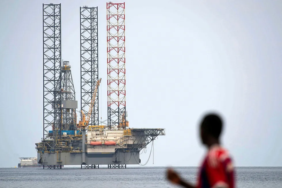 Deal finalised: a man passes a rig moored off Port-Gentil, Gabon