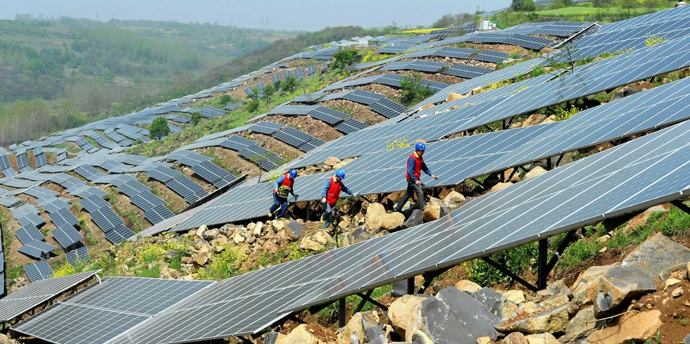 Chinese workers check PV modules in eastern China's Anhui province