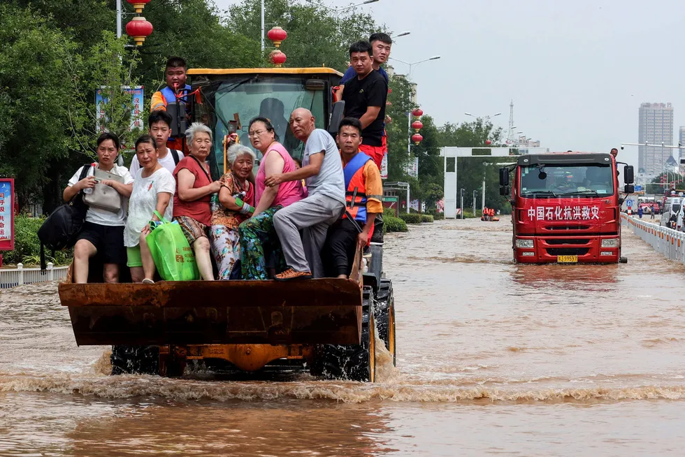 Evacuation: residents rescued by a loader from a flooded area in Xinxiang city, in China's central Henan province