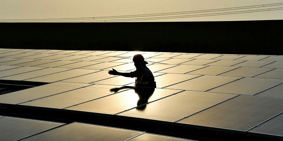 An Indian labourer installs solar panels at a site in Greater Noida, some 45km east of the capital New Delhi.