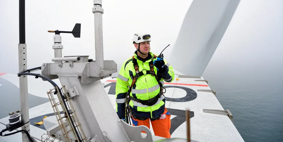 Service worker on nacelle of turbine at Nordsee Ost wind farm.